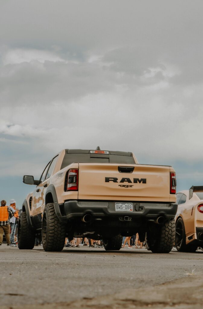 pexels photo 12523013 12523013 A robust RAM truck displayed at an outdoor car show under a clear blue sky, capturing automotive strength.
