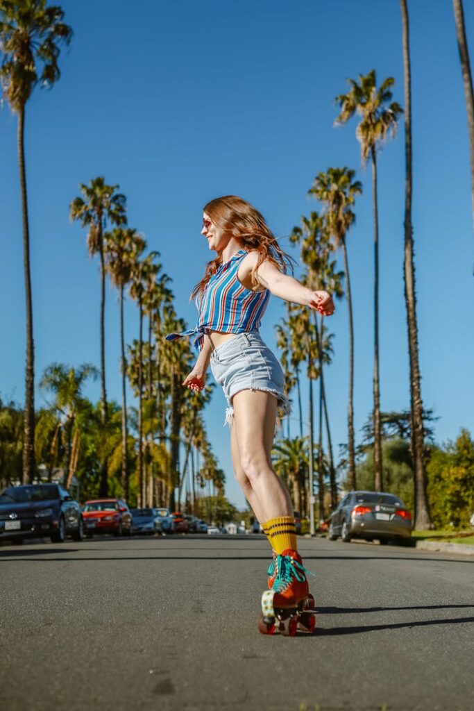 pexels photo 7335063 A carefree woman roller skating on a palm-lined street under a clear blue sky.